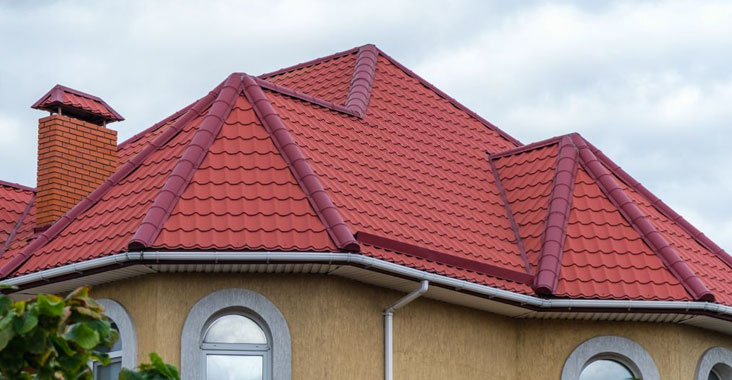 Parte alta de la fachada de una casa moderna con techo de Galvateja