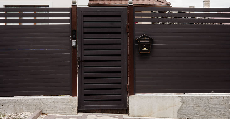 Fachada de casa moderna de un piso con puerta de lámina tipo tablero