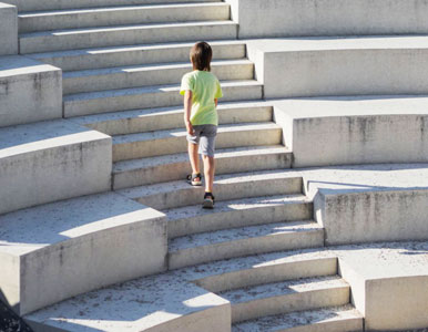 Niño ascendiendo por escalera con escalones increscendo