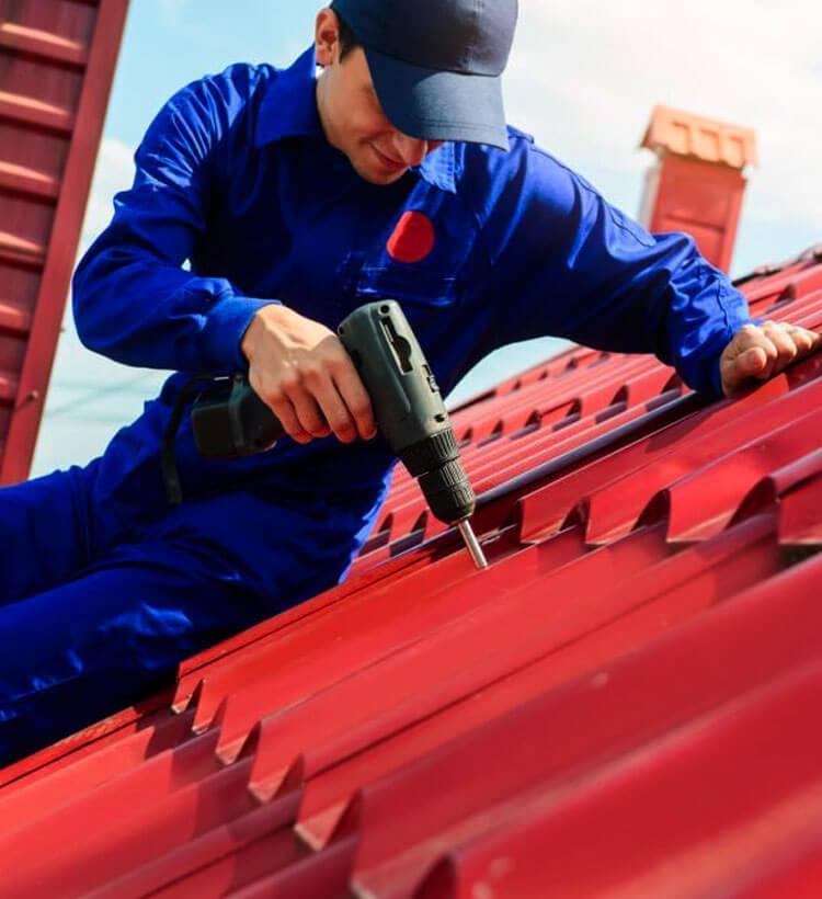 Trabajador instalando fachada con teja en una casa en remodelación