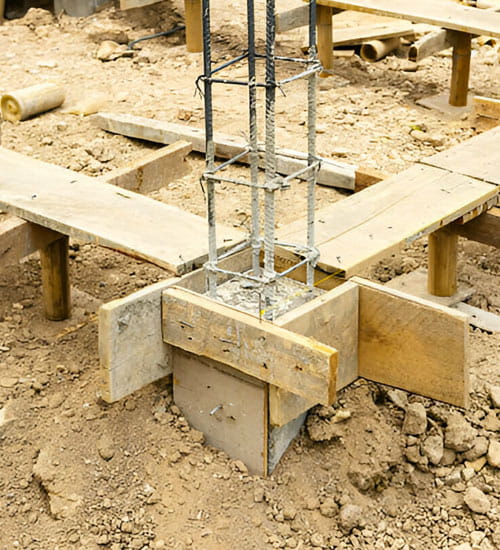 Zapata de cimentación de concreto en construcción, con varillas de refuerzo y encofrado visible
