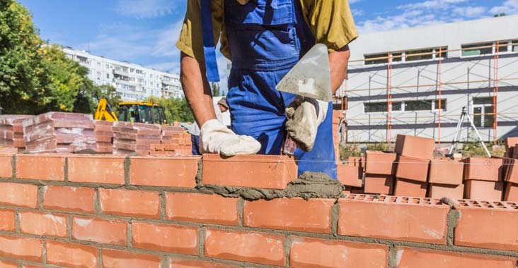 Albañiles levantando un muro de block para crear las cercas perimetrales de una casa