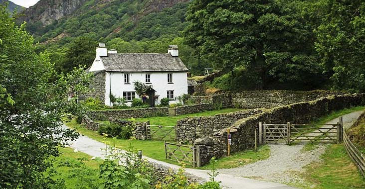 Casa rural siendo delimitada por los lados con muros de piedra