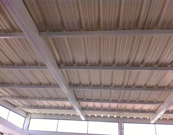 Techo de una construcción elaborado con lámina de PVC sobre una estructura de polines