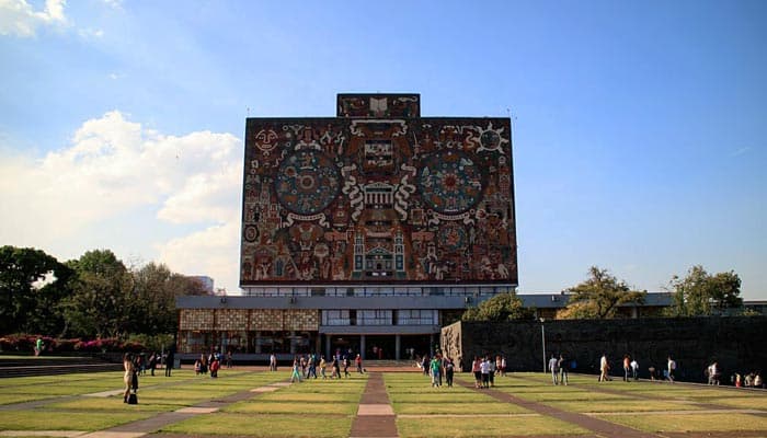 Alumnos y visitantes en las áreas verdes de la Biblioteca Central de la UNAM, ícono de la arquitectura moderna