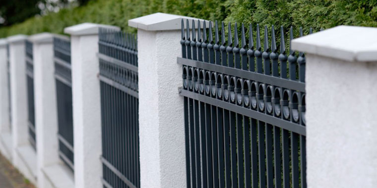 Barda para casa elaborada con cemento blanco y perfiles de herrería