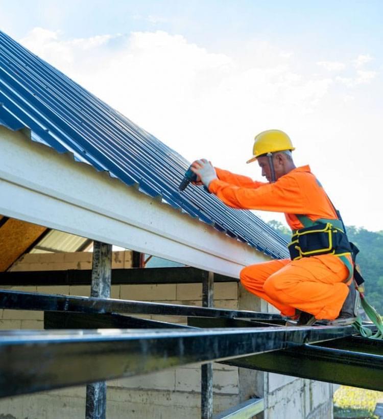 Trabajador de la construcción intalando un techo de lámina en una casa