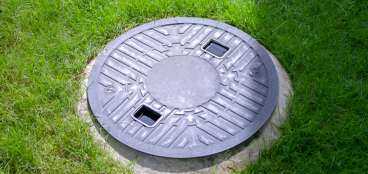 Tapa de una cisterna de concreto construída bajo tierra en un jardín