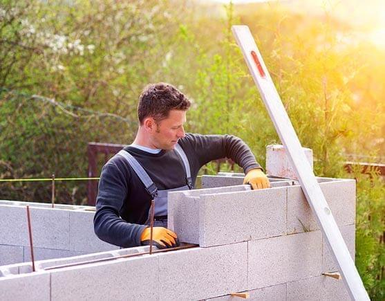 Trabajador de la construcción conolocando blocks en muro