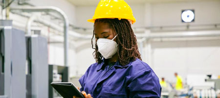 Empleada con mascarilla blanca y equipo de seguridad