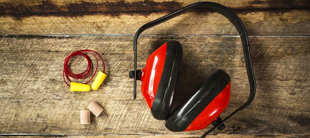 Tapones y orejeras de seguridad sobre madera