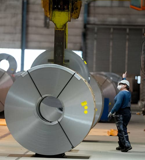 Empleada de ArcelorMittal haciendo maniebras con rollo de acero en bodega