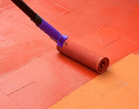 Trabajador aplicando el impermeabilizante elastomérico utilizando un rodillo