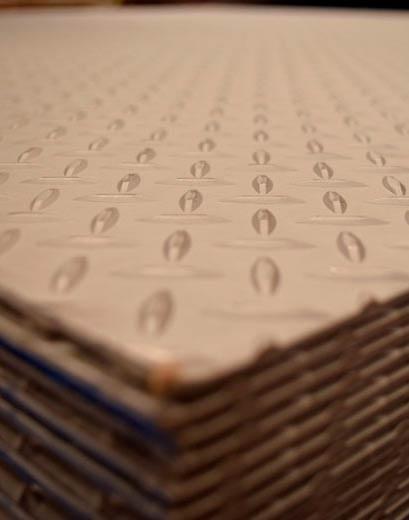Láminas antiderrapantes de acero colocadas una sobre otra en bodega.