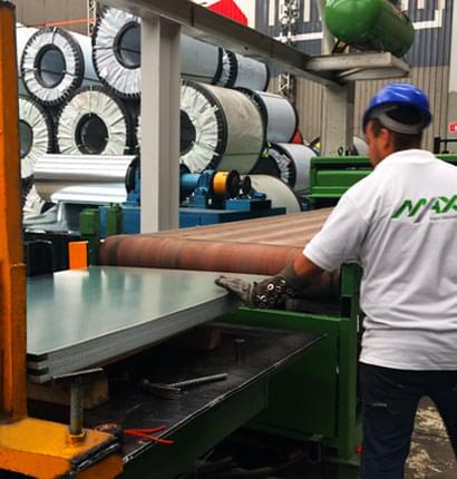 Trabajador manipulando hojas de lámina lisa en una construcción