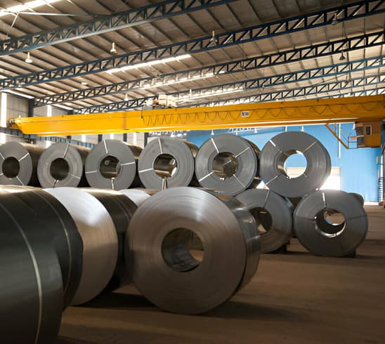 Rollos de lámina negra apilados unos sobre otros en una bodega