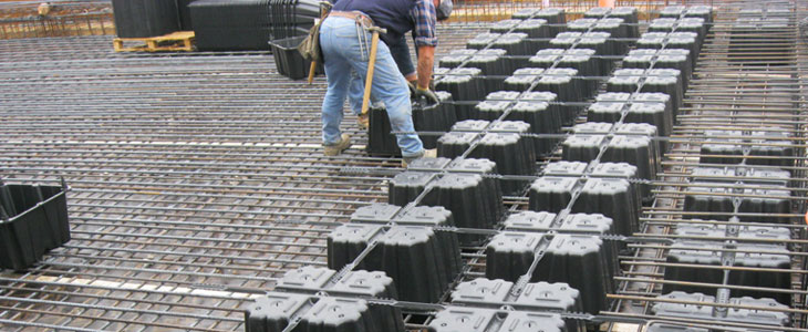 Trabajador instalando casetones sobre un entramado de varilla de acero