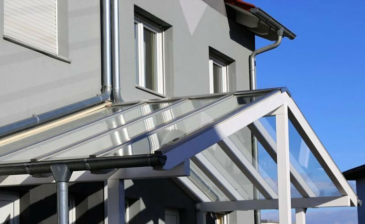 Marquesina a dos aguas con estructura de acero y policarbonato sólido en la cubierta