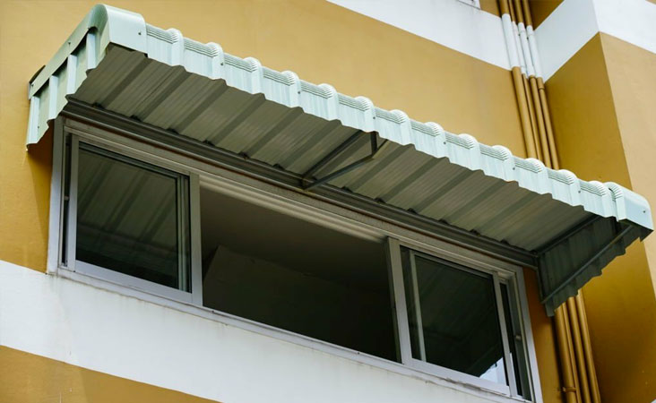 Marquesina de aluminio sobre la ventana del segundo piso de una casa