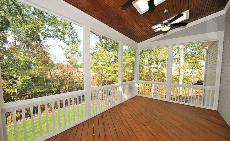 Marquesina de madera con diseño moderno colocada sobre el porche de una casa en el campo