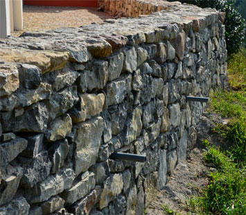Muro de contención elaborado con piedra en una zona boscosa