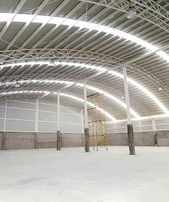 Nave industrial vacía con cubierta de arcotecho combinado con lámina traslúcida