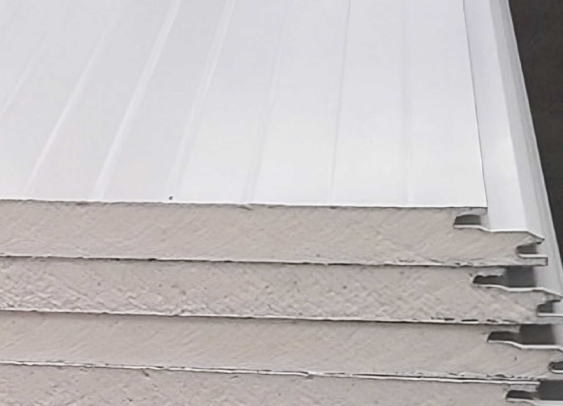 Paneles Sándwich Multymuro apilados junto a la construcción de un almacén.