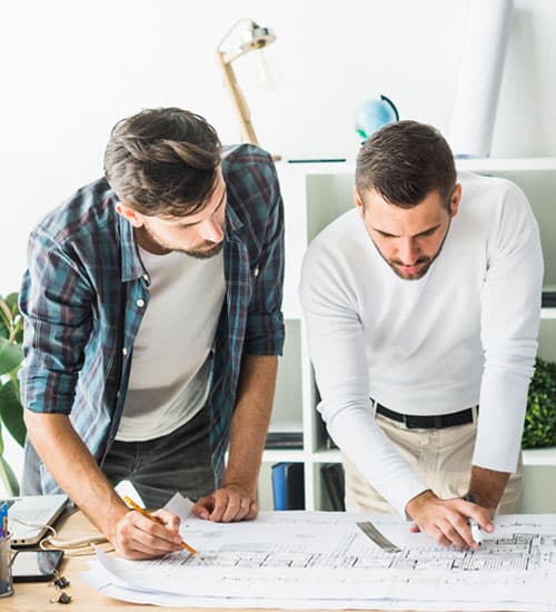 Trabajadores revisando los planos de una obra en construcción