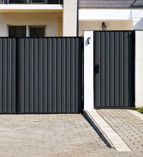 Puerta de herería elaborada con perfiles y lámina tipo tablero color negro