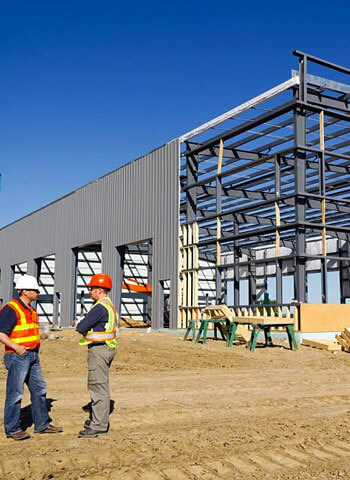 Trabajadores platicando frente a bodega en construcción