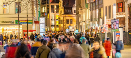 Vista a una calle con distintas tiendas llena de personas