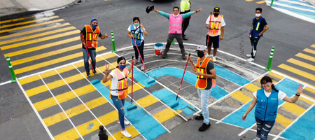 Grupo de personas pintando pasos peatonales