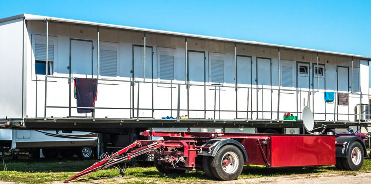 Casa prefabricada formada a partir de un contenedor siendo cargada sobre un trailer