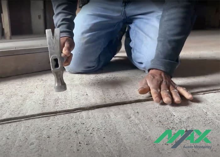 Persona golpeando con martillo un tramo de alambrón para estribo