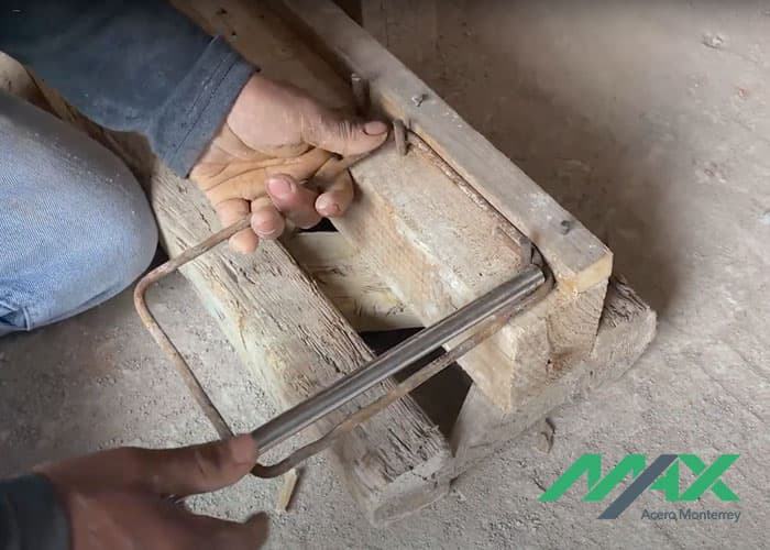 Trabajador de la construcción concluyendo los dobleces de un estribo de alambrón con tubo