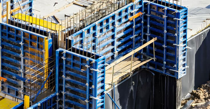 Construcción en progreso con cimbra metálica azul, asegurando una base sólida para el nuevo edificio