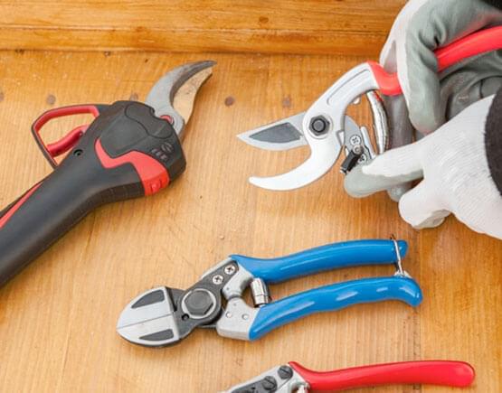 Diferentes tipos de tijeras  para cortar lámina colocadas sobre una mesa de trabajo.