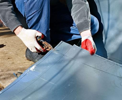 Trabajador realizando cortes con tijeras para lámina de acero