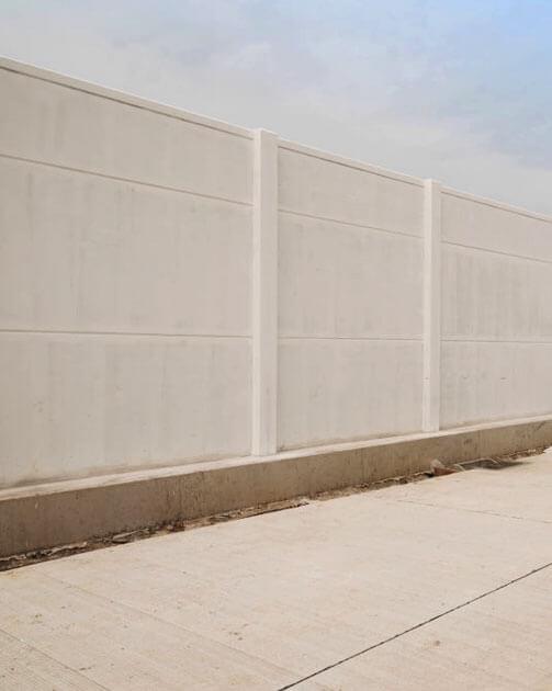 Construcción de una barda prefabricada con cemento y acero.