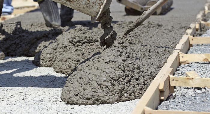 Mezcla de hormigón fresco dentro de una cimbra metálica para guarnición