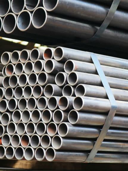 Tubería industrial apilada al interior de una bodega de acero