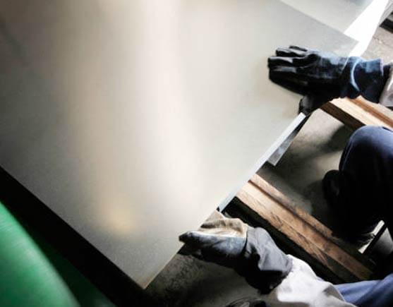 Persona manipulando lámina de acero negro.