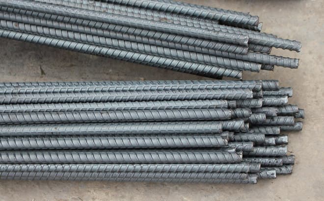 Varillas corrugadas extendidas apiladas sobre piso
